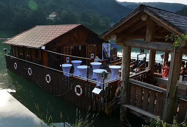 Schwimmende Almhütte leeren Tischen und Bänken vor Anker auf der Enns